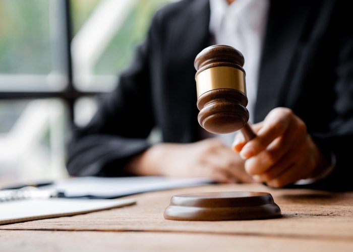 A person holding the hammer of justice, the concept of a lawyer or a law enforcement officer is holding a hammer similar to the judgment of a lawsuit.