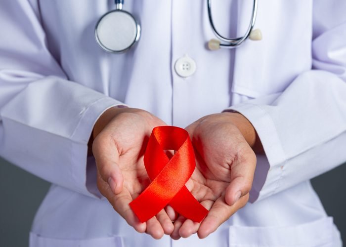 The doctor holds a red ribbon, HIV awareness awareness, World AIDS Day and World Sexual Health Day.